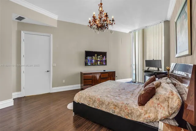 a bedroom with a bed and a chandelier