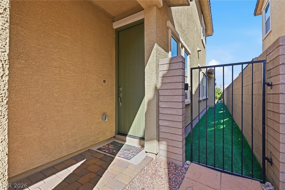 250 Dedication Avenue Henderson, NV 89011 - Photo 4 of 67 View of exterior entry featuring a gate and stucco siding
