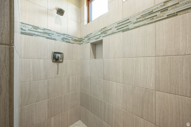 2331 West Entrada Trail, Unit 61 St. George, UT 84770 - Photo 55 of 69 Tiled shower enclosure featuring light-toned large format tiles, decorative glass accent tiling, and a built-in shower niche
