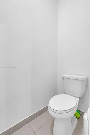 a white toilet sitting next to a shower