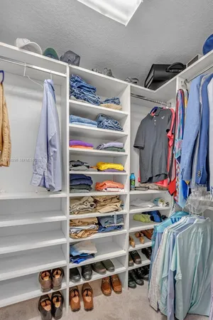 a view of walk in closet with clothes and shoes