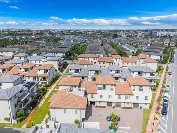 an aerial view of residential houses with outdoor space and parking