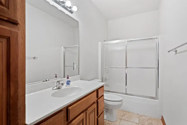 a bathroom with a toilet a sink a mirror and vanity