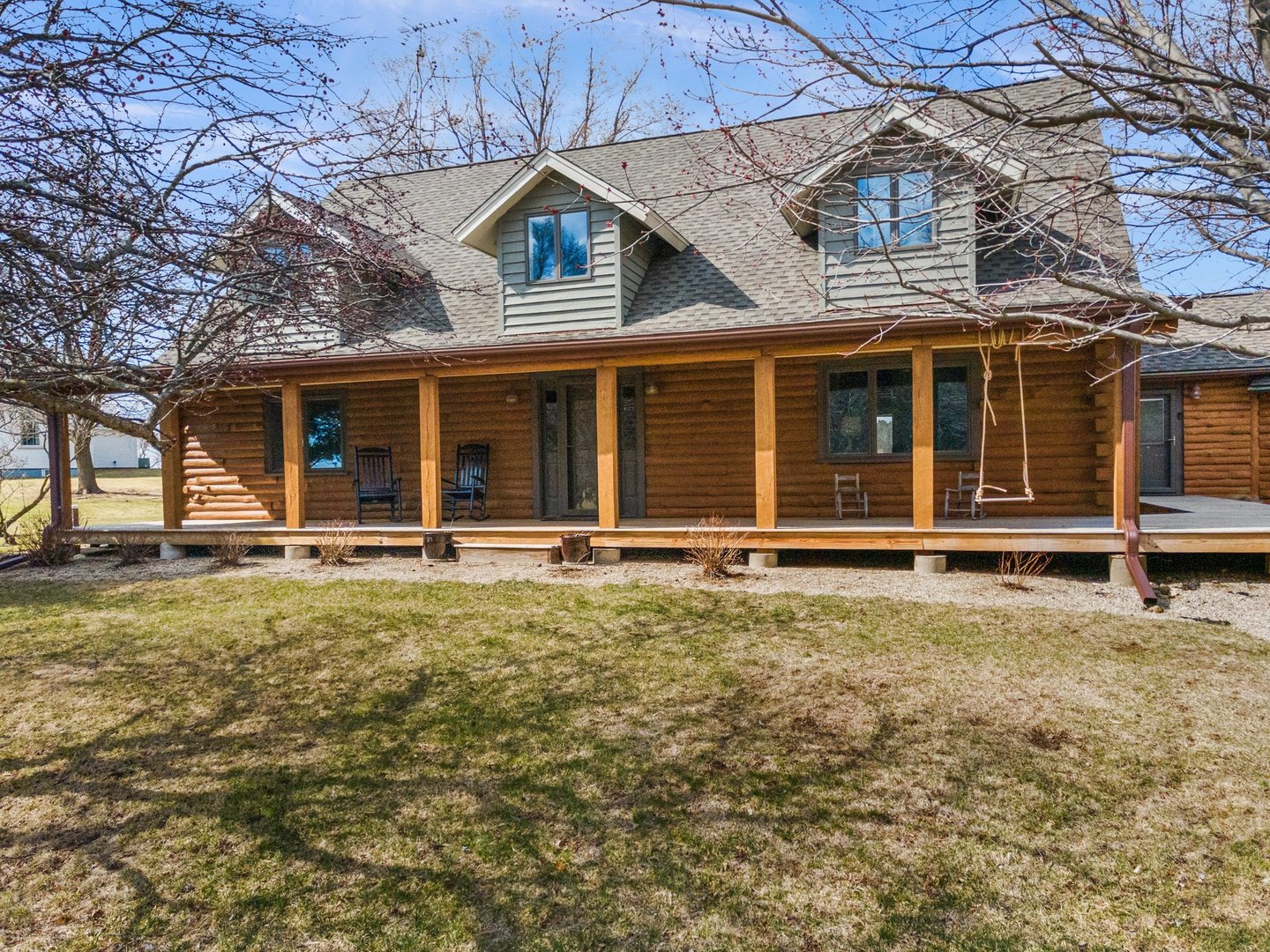 1490 Flora Church Road Kirkland, IL 60146 - Photo 4 of 49 a view of a white house with large windows and a small yard