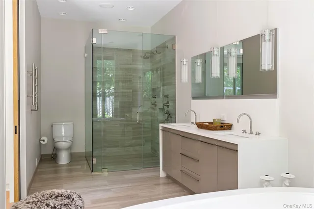 a bathroom with a sink a toilet and shower