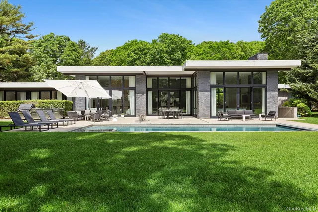 a swimming pool view with a seating space and a garden