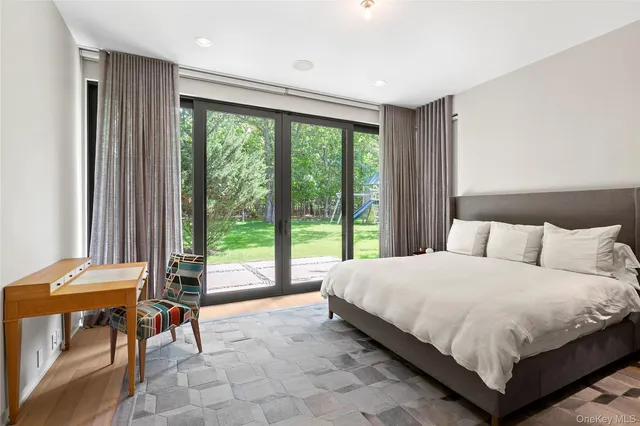 a large bedroom with a bed and a view of chair