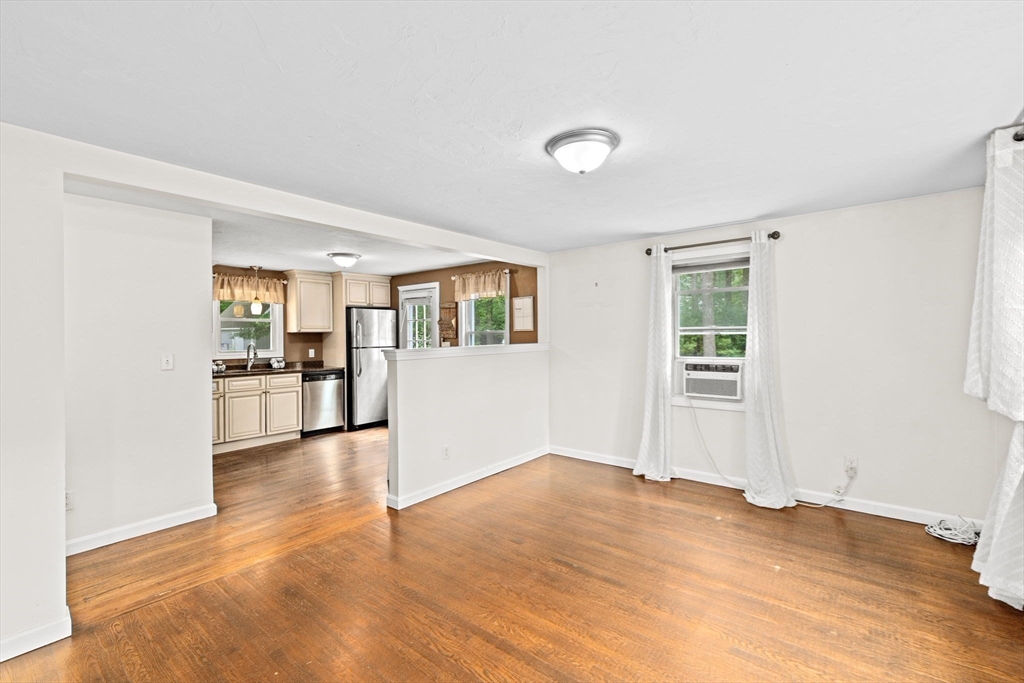 74 Rochester Road Carver, MA 02330 - Photo 10 of 31 a view of a livingroom with wooden floor and a kitchen