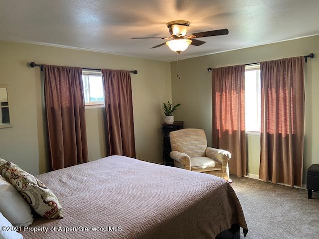 1394 Firethorn Drive Rifle, CO 81650 - Photo 40 of 43 a bedroom with a large bed and a chandelier