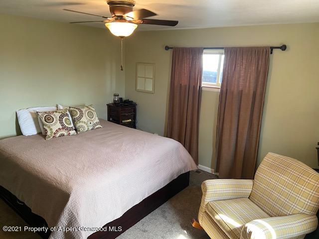 1394 Firethorn Drive Rifle, CO 81650 - Photo 41 of 43 a bedroom with a bed and a chandelier