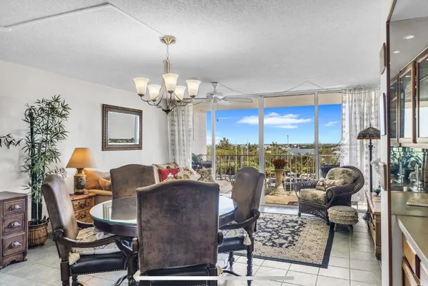 a living room with furniture a chandelier and a dining table