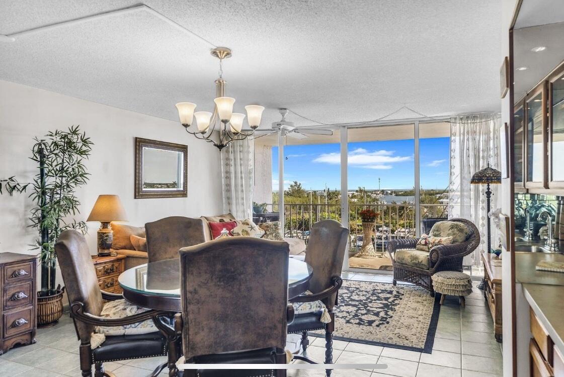 2000 Coco Plum Drive, Unit 603 Marathon, FL 33050 - Photo 6 of 22 a living room with furniture a chandelier and a dining table