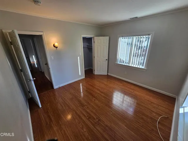 a view of a livingroom with wooden floor and stairs