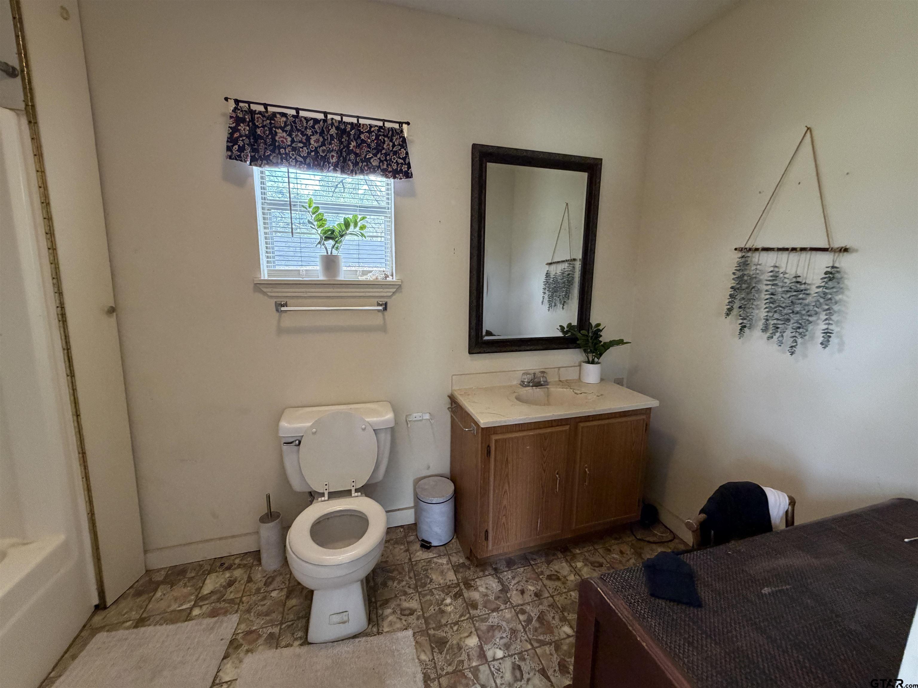 609 Walnut Mineola, TX 75773 - Photo 18 of 23 a bathroom with a toilet a sink and mirror