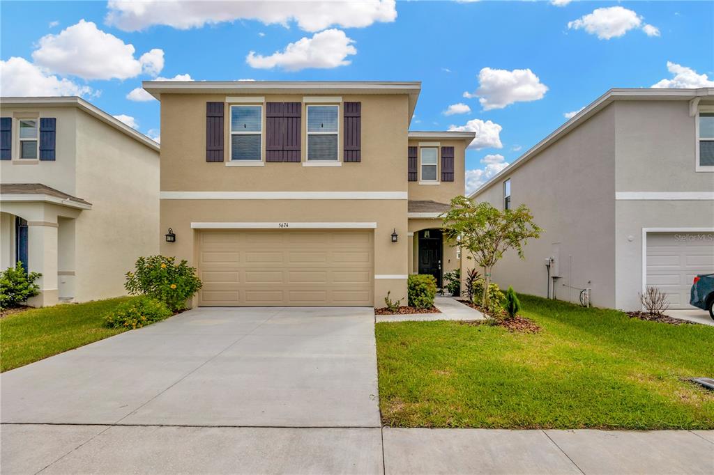 5674 Banbury Ridge Run Wesley Chapel, FL 33545 - Photo 1 of 40 a front view of a house with a yard and garage