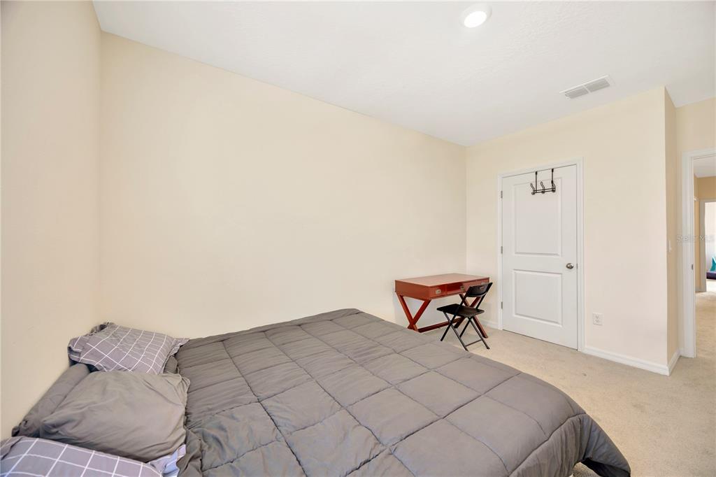 5674 Banbury Ridge Run Wesley Chapel, FL 33545 - Photo 17 of 40 a bedroom with a bed and chair