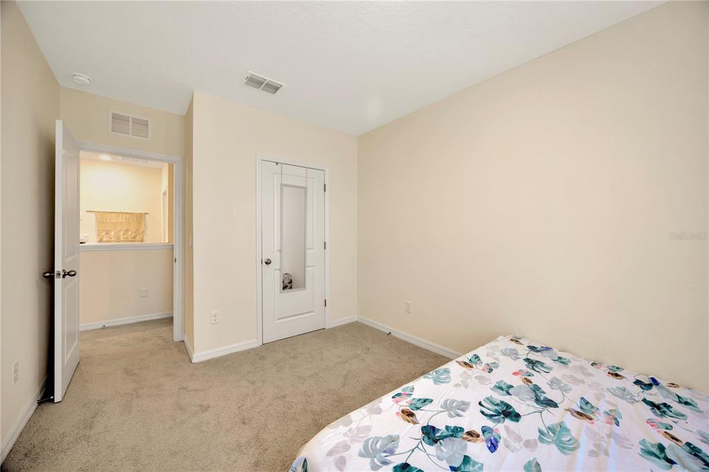 5674 Banbury Ridge Run Wesley Chapel, FL 33545 - Photo 19 of 40 a bedroom with a bed and a rug