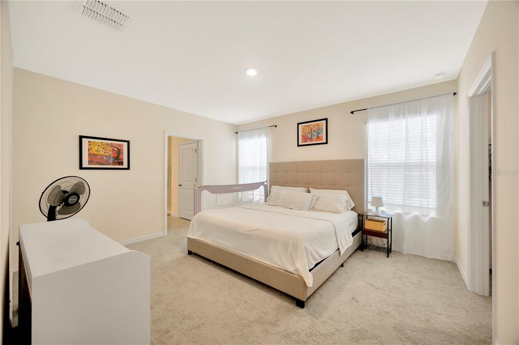 5674 Banbury Ridge Run Wesley Chapel, FL 33545 - Photo 21 of 40 a spacious bedroom with a bed and a window