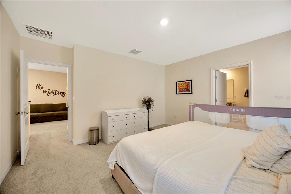 5674 Banbury Ridge Run Wesley Chapel, FL 33545 - Photo 22 of 40 a bedroom with a bed and a mirror