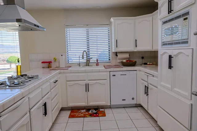 a kitchen with stainless steel appliances white cabinets and a sink