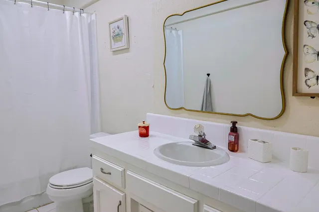 a bathroom with a sink vanity mirror and toilet