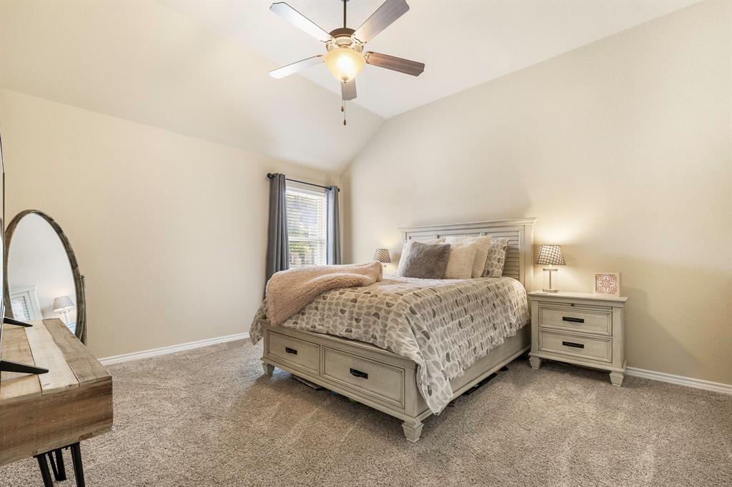 103 Brandy Lane Stephenville, TX 76401 - Photo 20 of 37 a spacious bedroom with a bed a chandelier and a dresser