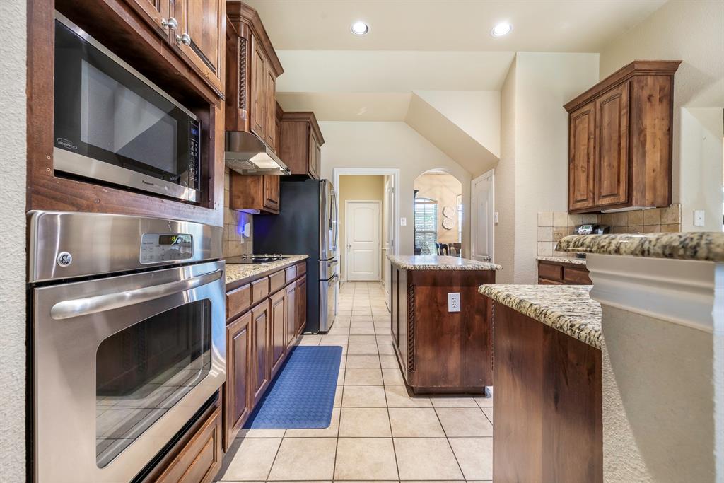 103 Brandy Lane Stephenville, TX 76401 - Photo 10 of 37 a kitchen with stainless steel appliances granite countertop a stove a sink and a microwave