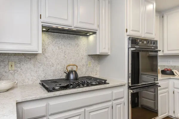 a dining room with stainless steel appliances kitchen island granite countertop a kitchen island a table and a refrigerator