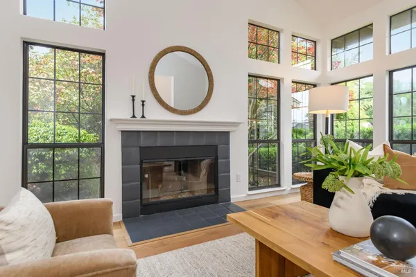a living room with furniture a large window and a fireplace