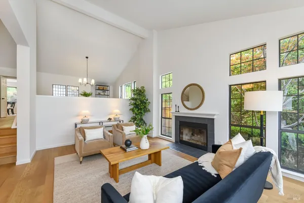 a living room with furniture a fireplace a lamp and a large window