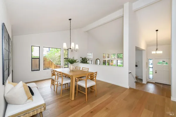 a dining room with furniture a chandelier and wooden floor