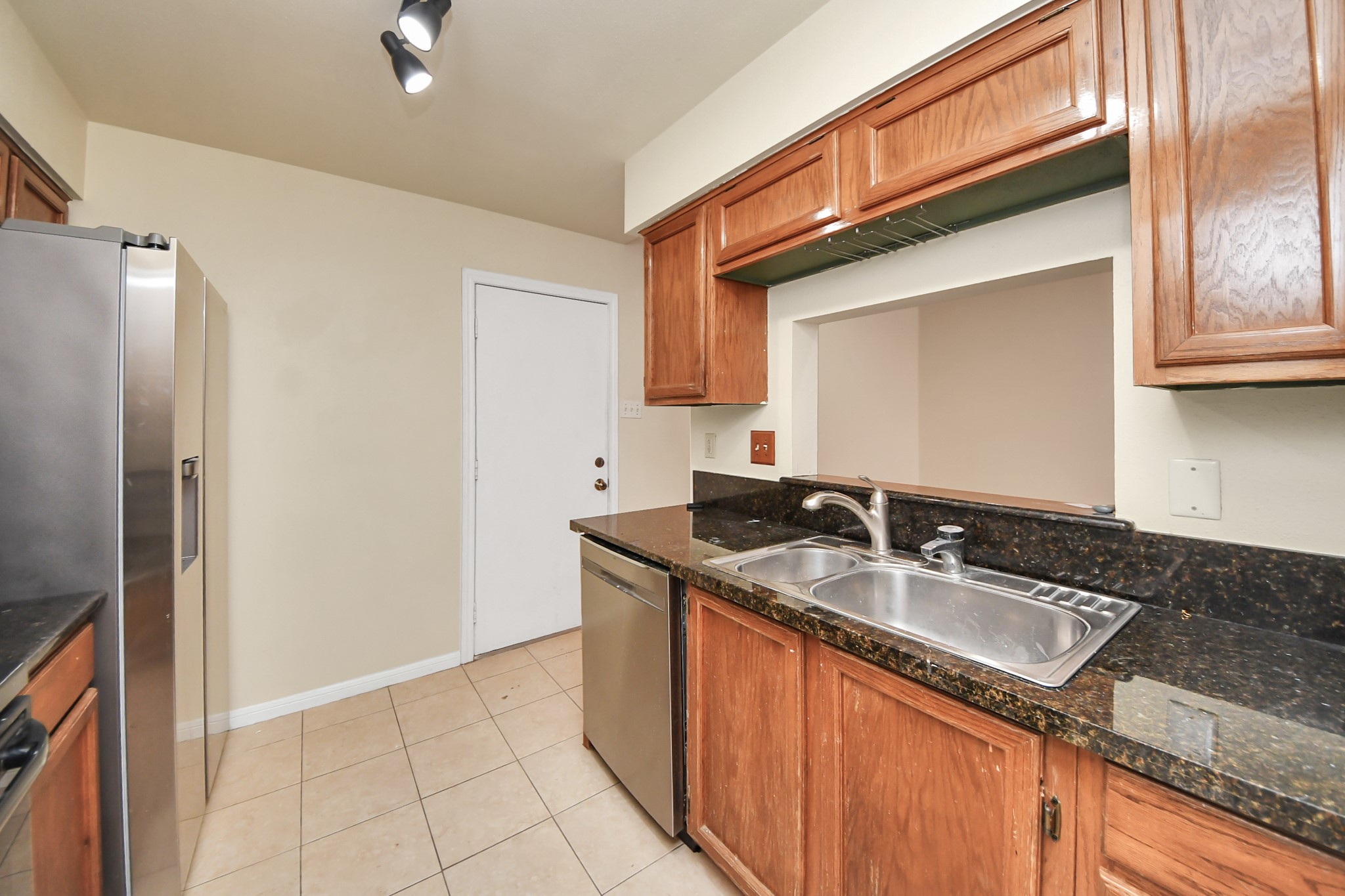 7447 Cambridge Street, Unit 106 Houston, TX 77054 - Photo 11 of 40 a kitchen with granite countertop a sink and a refrigerator