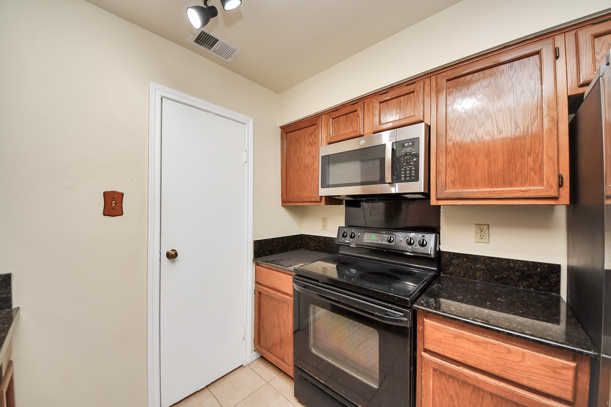 7447 Cambridge Street, Unit 106 Houston, TX 77054 - Photo 14 of 40 a kitchen with stainless steel appliances granite countertop a stove and a microwave