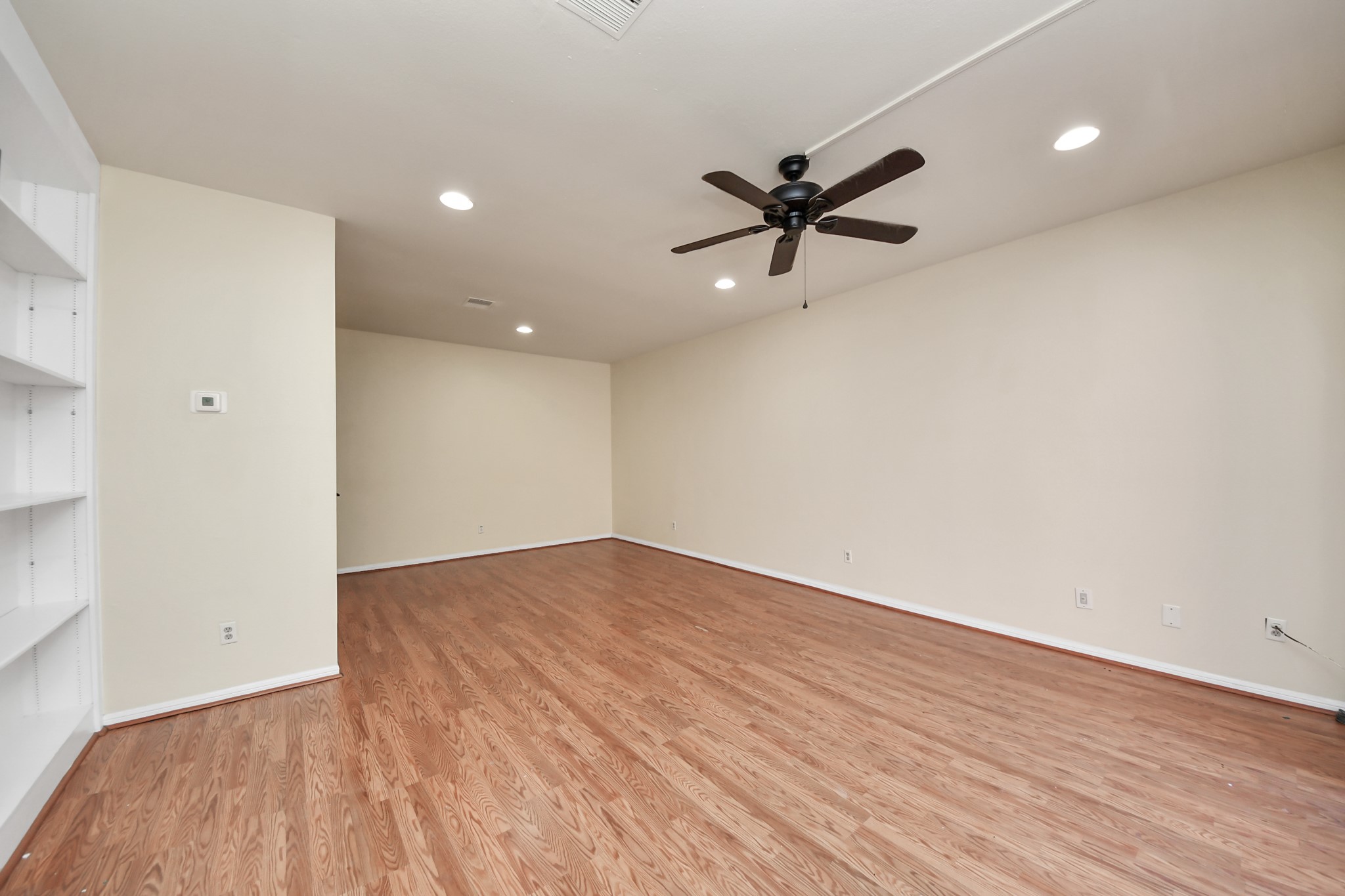 7447 Cambridge Street, Unit 106 Houston, TX 77054 - Photo 18 of 40 an empty room with wooden floor and a ceiling fan