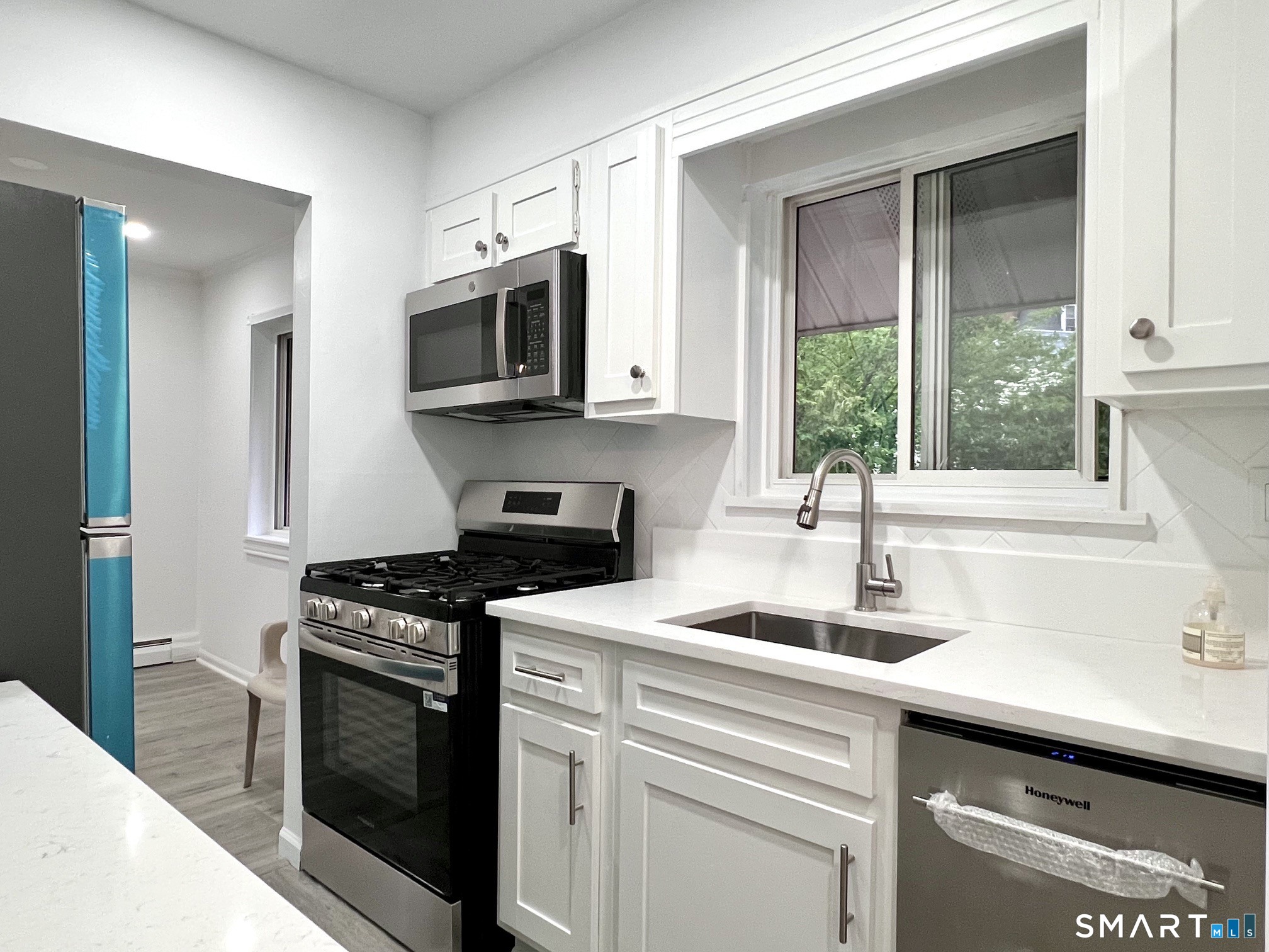 208 Flax Hill Road, Unit 32 Norwalk, CT 06854 - Photo 3 of 12 a kitchen with stainless steel appliances granite countertop a sink a stove and a microwave