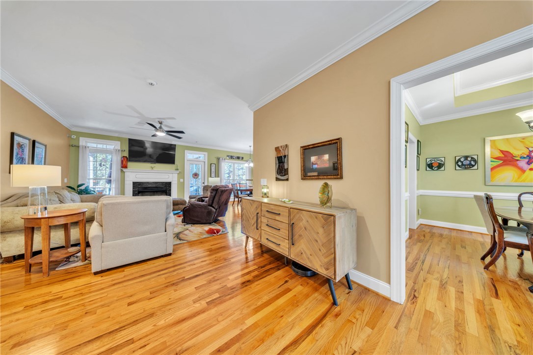 648 Mountain View Road Williamston, SC 29697 - Photo 11 of 42 Hardwood floors stretch across this inviting living area, leading to a fireplace with a TV mounted above.