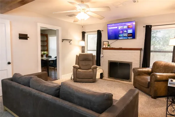 a living room with furniture a flat screen tv and a fireplace