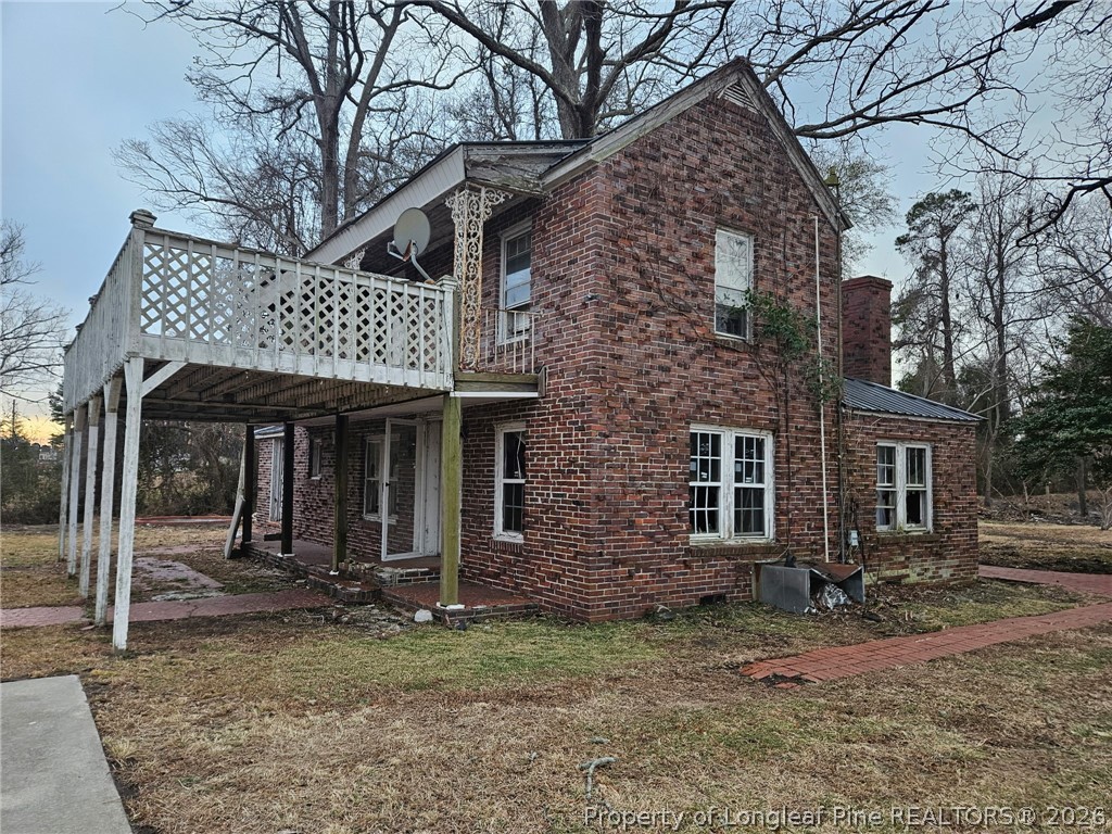 1737 West Carthage Road Lumberton, NC 28360 - Photo 29 of 39 a view of a brick house with large windows and a small yard