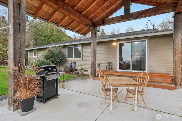 a backyard of a house with barbeque oven table and chairs