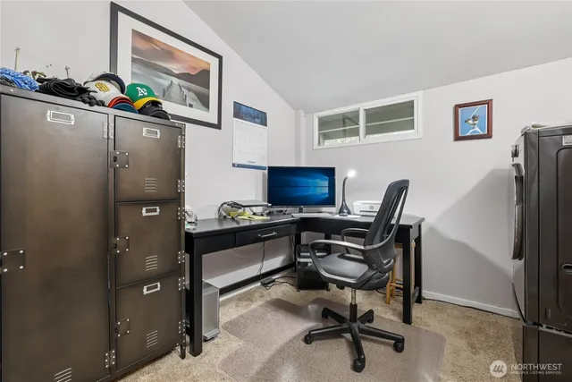 a view of a workspace with furniture and a window