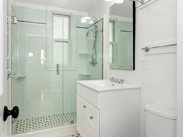 a bathroom with a sink a toilet and shower