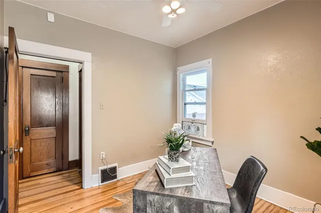 a view of a kitchen with refrigerator and wooden floor