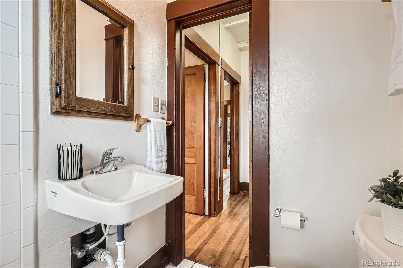 827 South Sherman Street Denver, CO 80209 - Photo 19 of 27 a bathroom with a sink a toilet and mirror