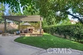 a view of a patio with table and chairs potted plants and large tree