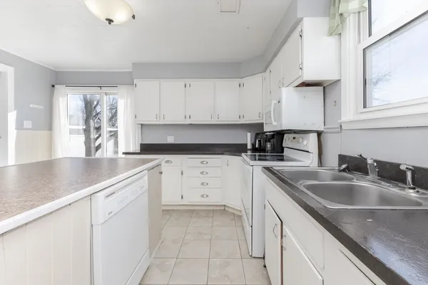 a kitchen with cabinets appliances a sink and a counter top space