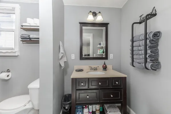 a bathroom with a toilet a sink and mirror