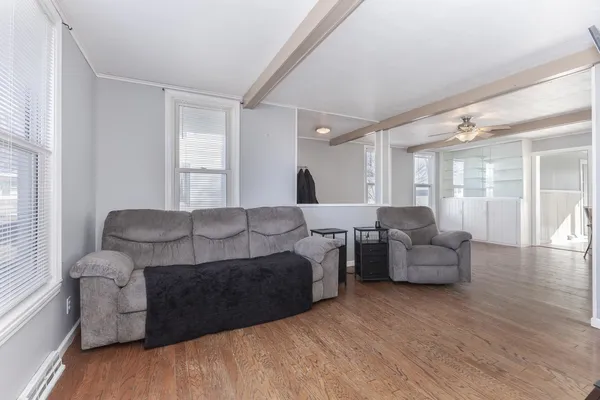 a living room with furniture and a wooden floor