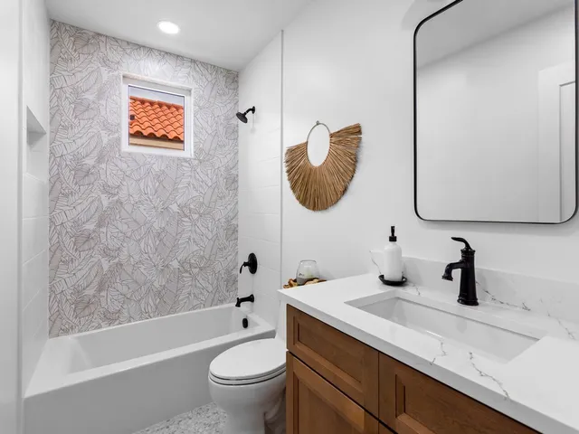 a bathroom with a tub sink and mirror