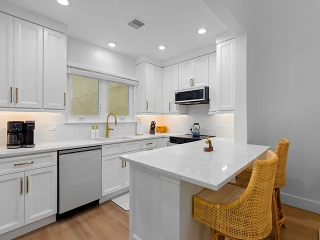 a kitchen with a sink cabinets and wooden floor