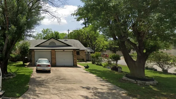 a front view of a house with a yard and trees